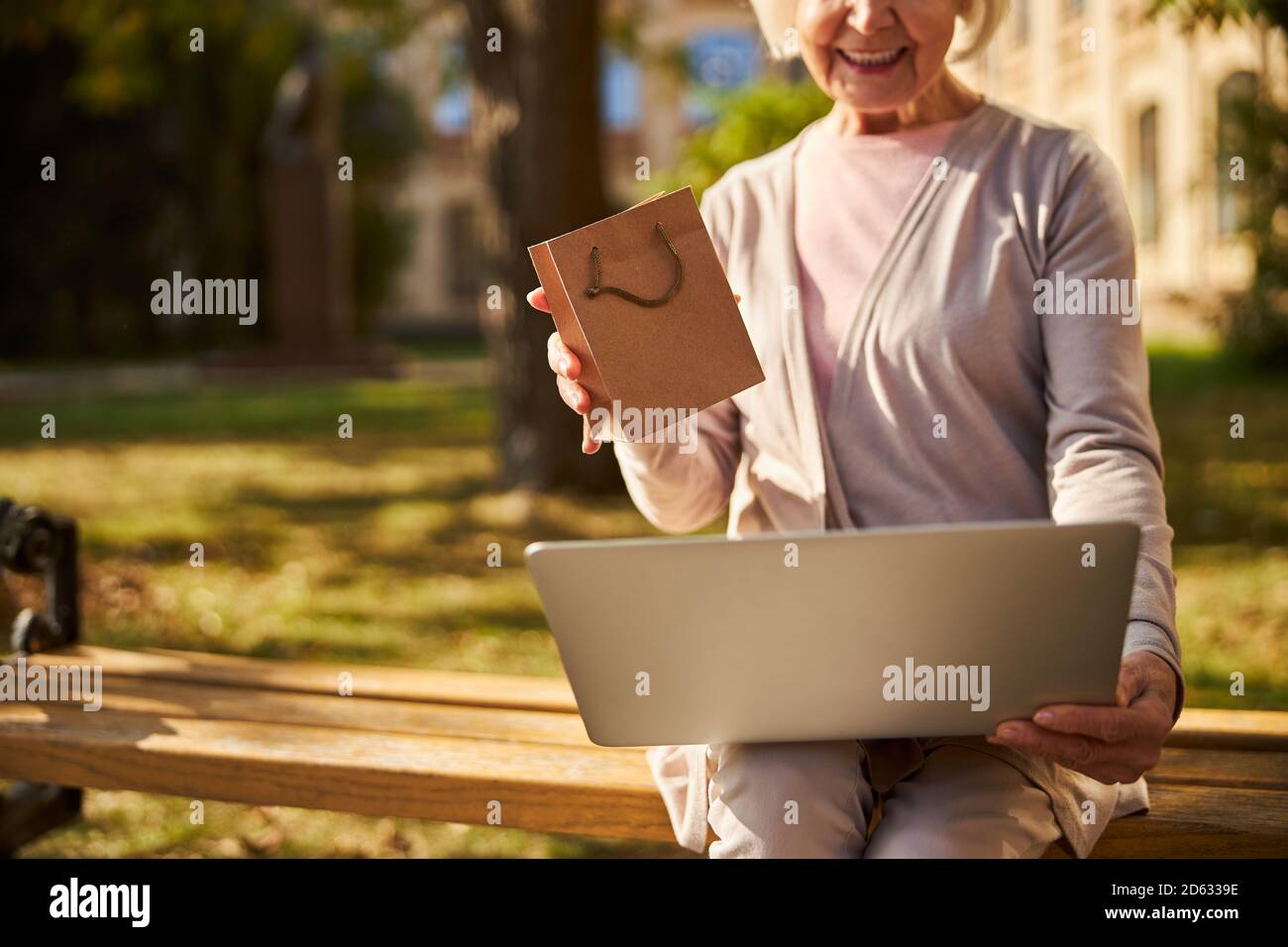 Content old lady using laptop on her knees Stock Photo