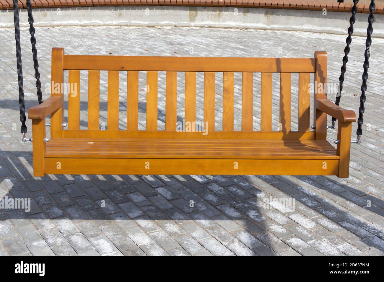 New swing bench in the park. Swing in the form of a wooden park bench. Swing in the recreation