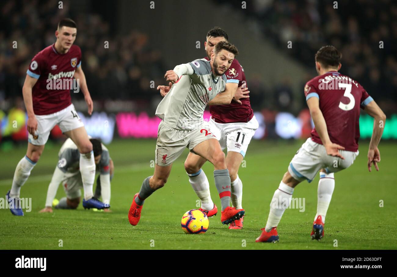 Liverpool's Adam Lallana (centre left) and West Ham United's Robert Snodgrass (centre right) battle for the ball Stock Photo