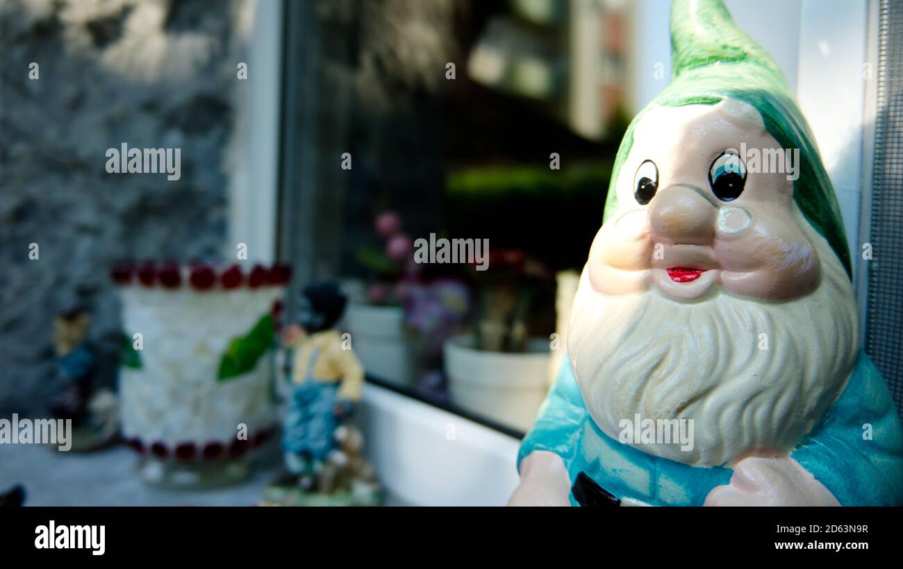 Garden gnome by a window of a house Stock Photo