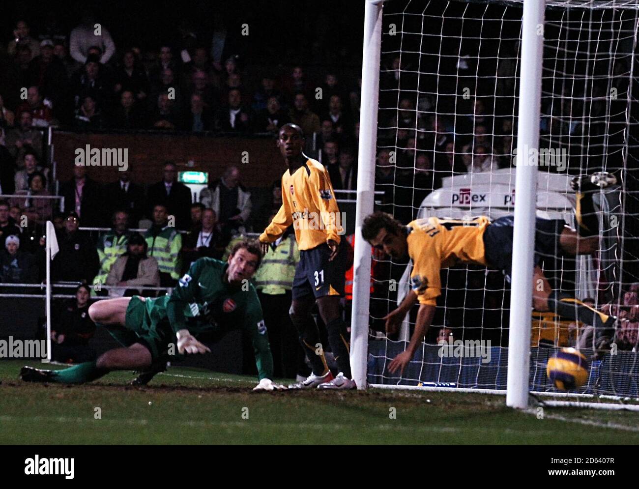 Fulham's Brian McBride (out of pic) scores the opening goal past Arsenal's goalkeeper Jens Lehmann and Mathieu Flamini (r) Stock Photo