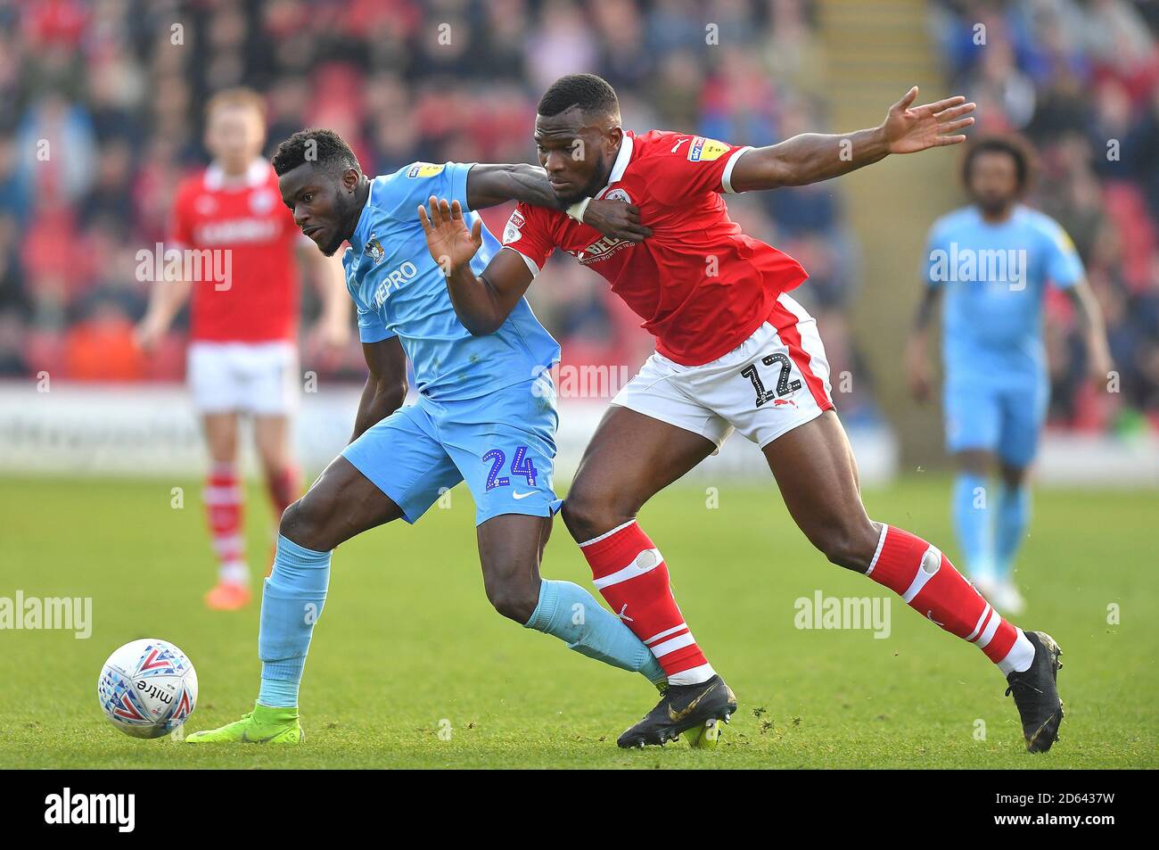 Coventry City's Bright Enobakhare (left) battles with Barnsley's Dimitri Cavare Stock Photo