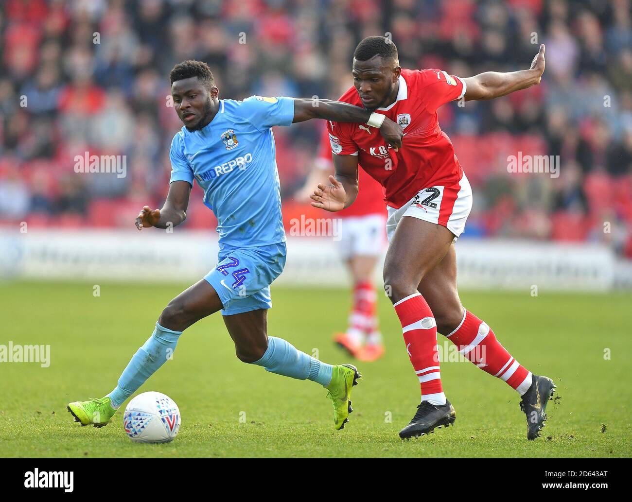 Coventry City's Bright Enobakhare (left) battles with Barnsley's Dimitri Cavare Stock Photo