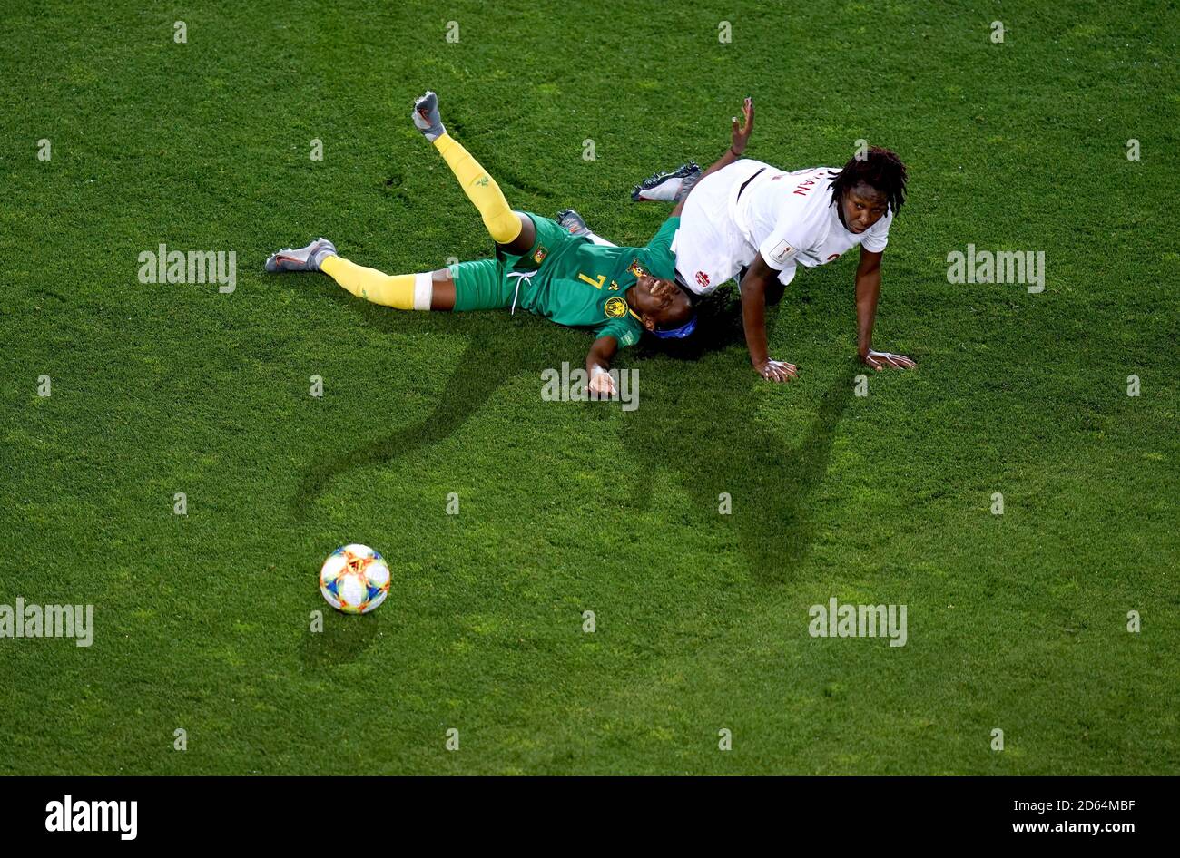 Cameroon's Gabrielle Onguene (left) and Canada's Kadeisha Buchanan lay on the pitch after clashing Stock Photo