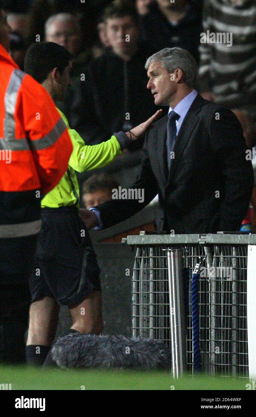 Blackburn Rovers' manager Mark Hughes is cautioned by the fourth official Stock Photo