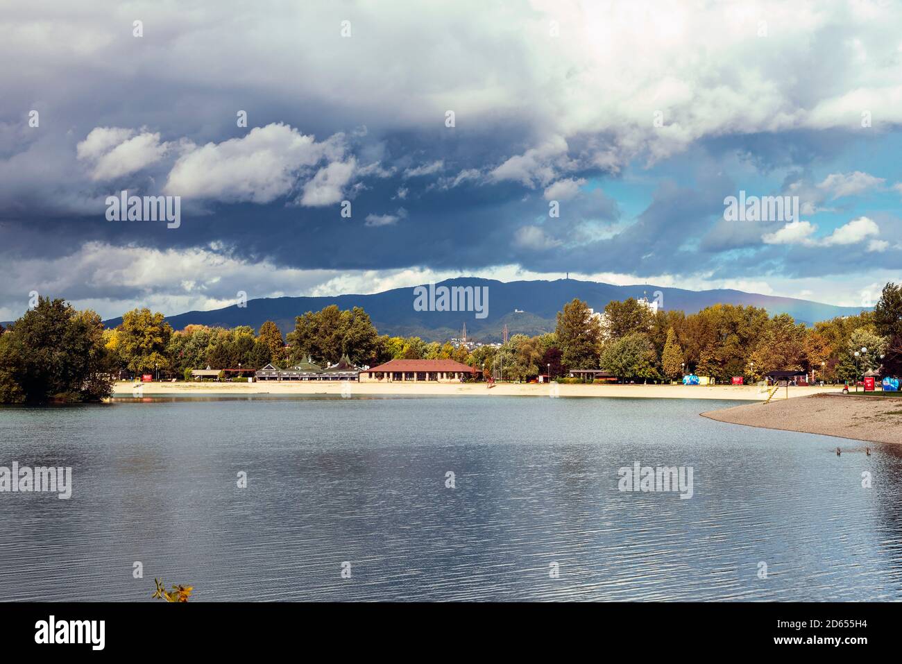 Lake and mountain against blue sky with clouds. Stormy weather. Jarun lake, Zagreb, Croatia. Stock Photo