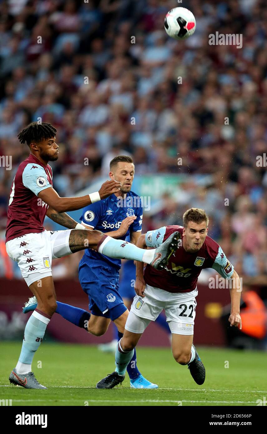 Aston Villa's Tyrone Mings (left) battles for the ball with team-mate Bjorn Engels (right) and Everton's Gylfi Sigurdsson (centre) Stock Photo