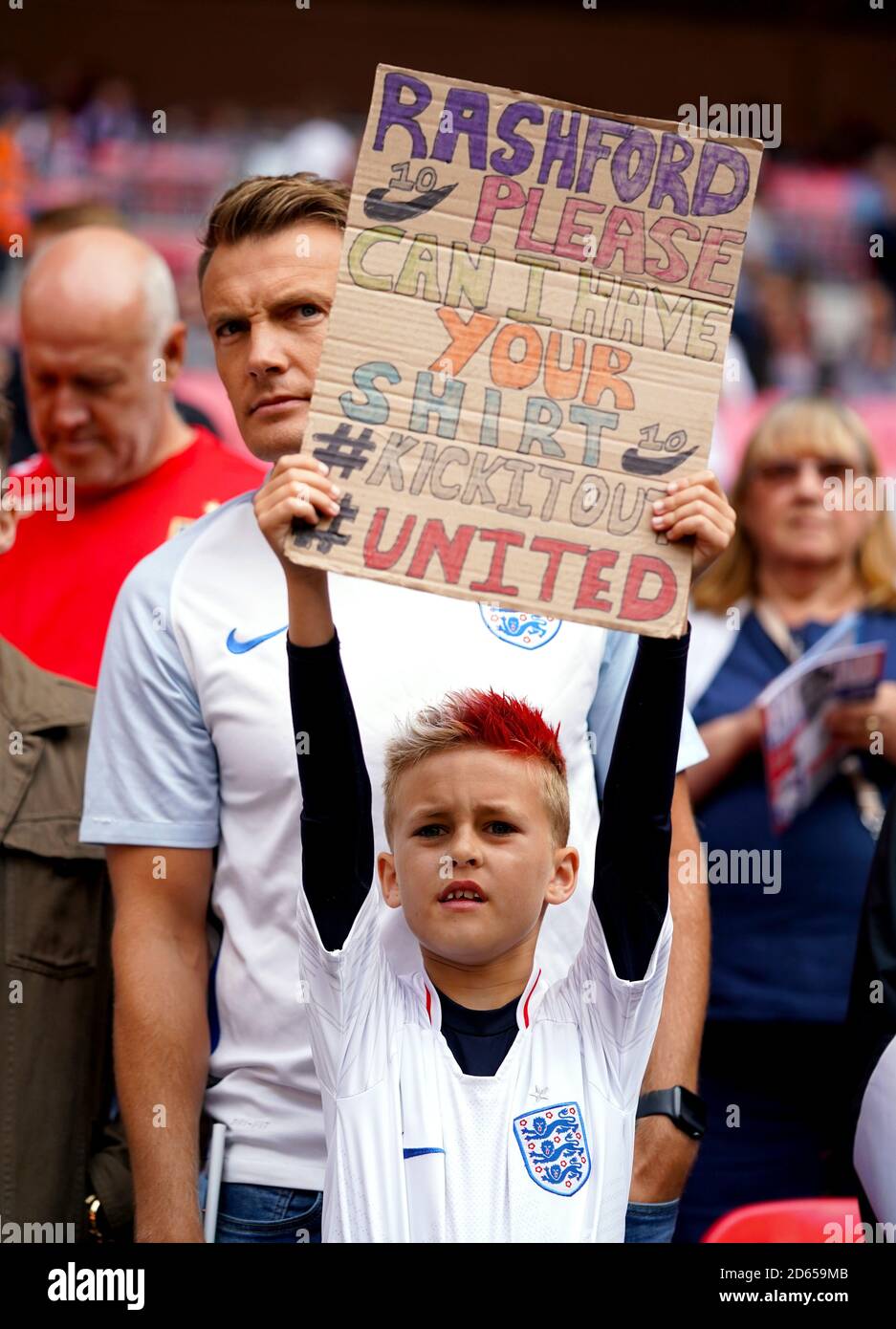 A young England fan holds a sign asking Marcus Rashford for his shirt ahead of the match Stock Photo
