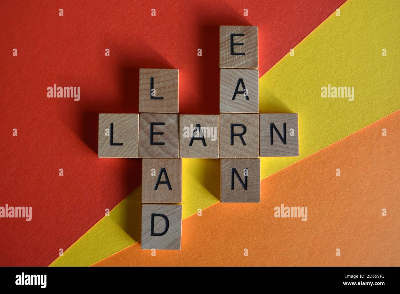 Lead, Learn, Earn, words in wooden alphabet letters in crossword form isolated on colorful background Stock Photo