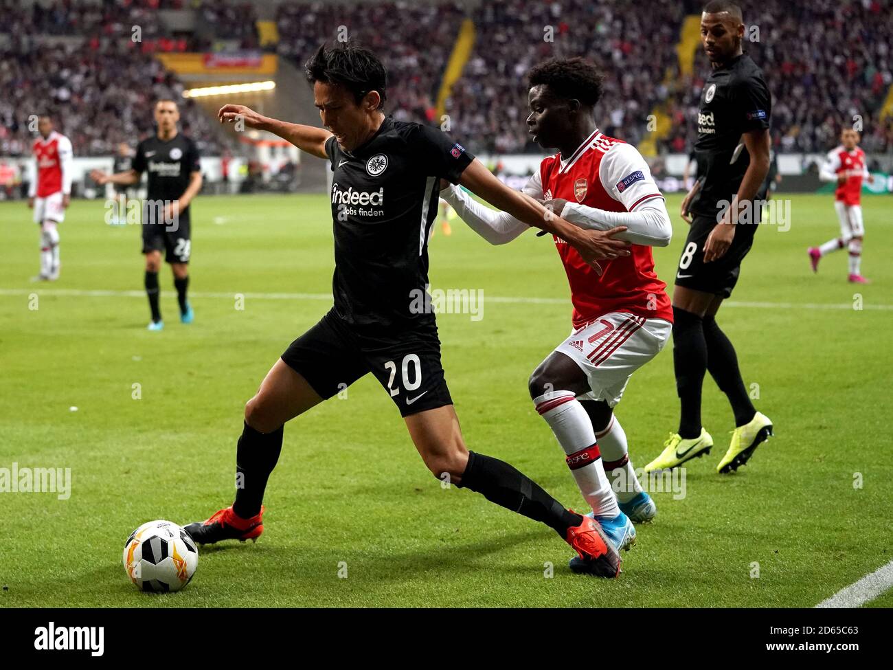 Eintracht Frankfurt's Makoto Hasebe (left) and Arsenal's Bukayo Saka battle for the ball Stock Photo