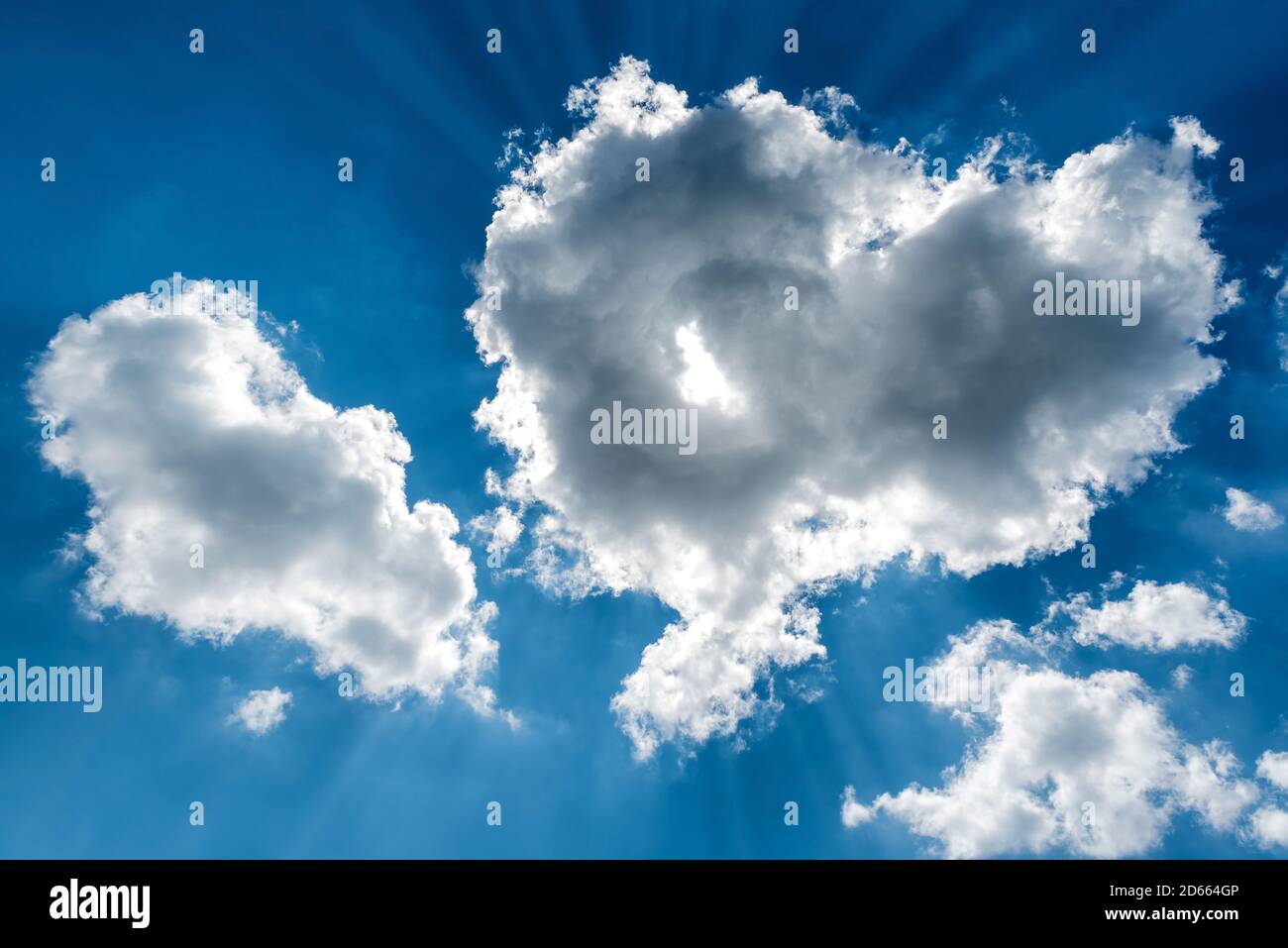 White cumulus clouds and a blue sky with sun rays Stock Photo - Alamy