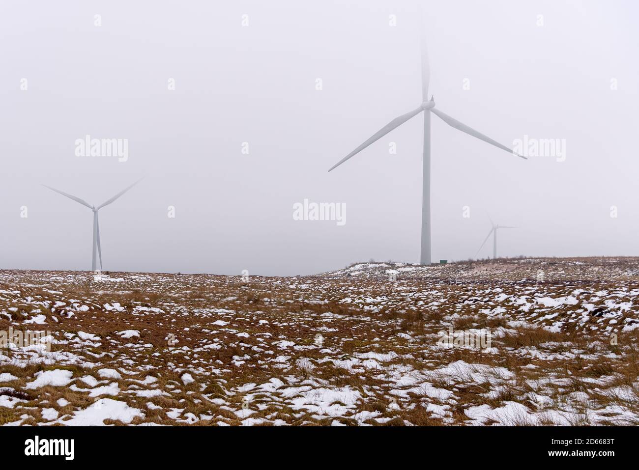 Snowy Wind farm shrouded in fog on a winter day Stock Photo