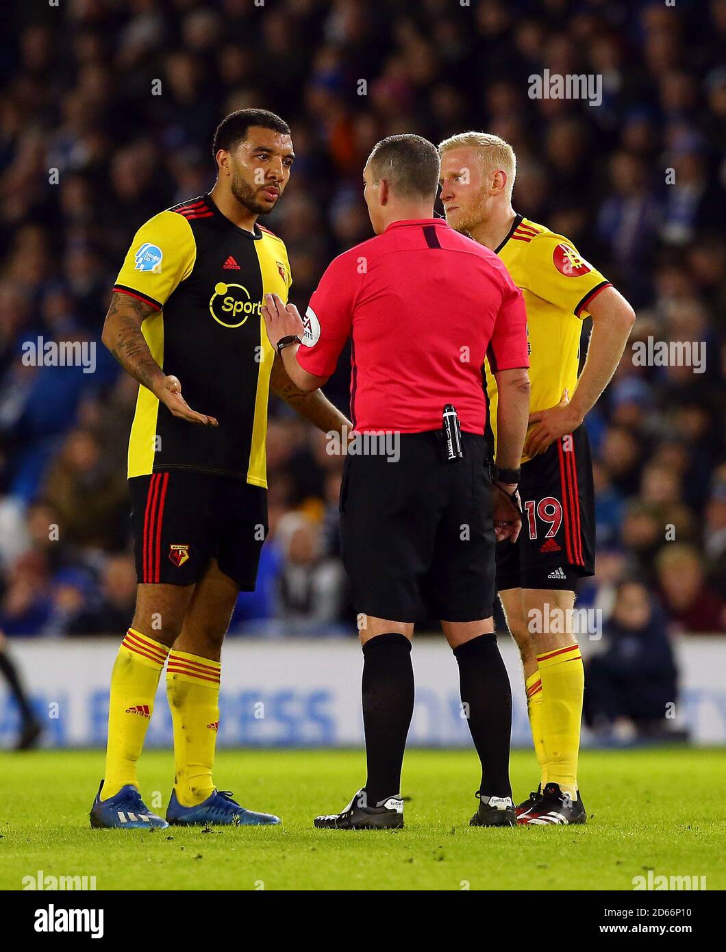 Watford's Troy Deeney (left) and Will Hughes speak to referee Kevin Friend  Stock Photo - Alamy