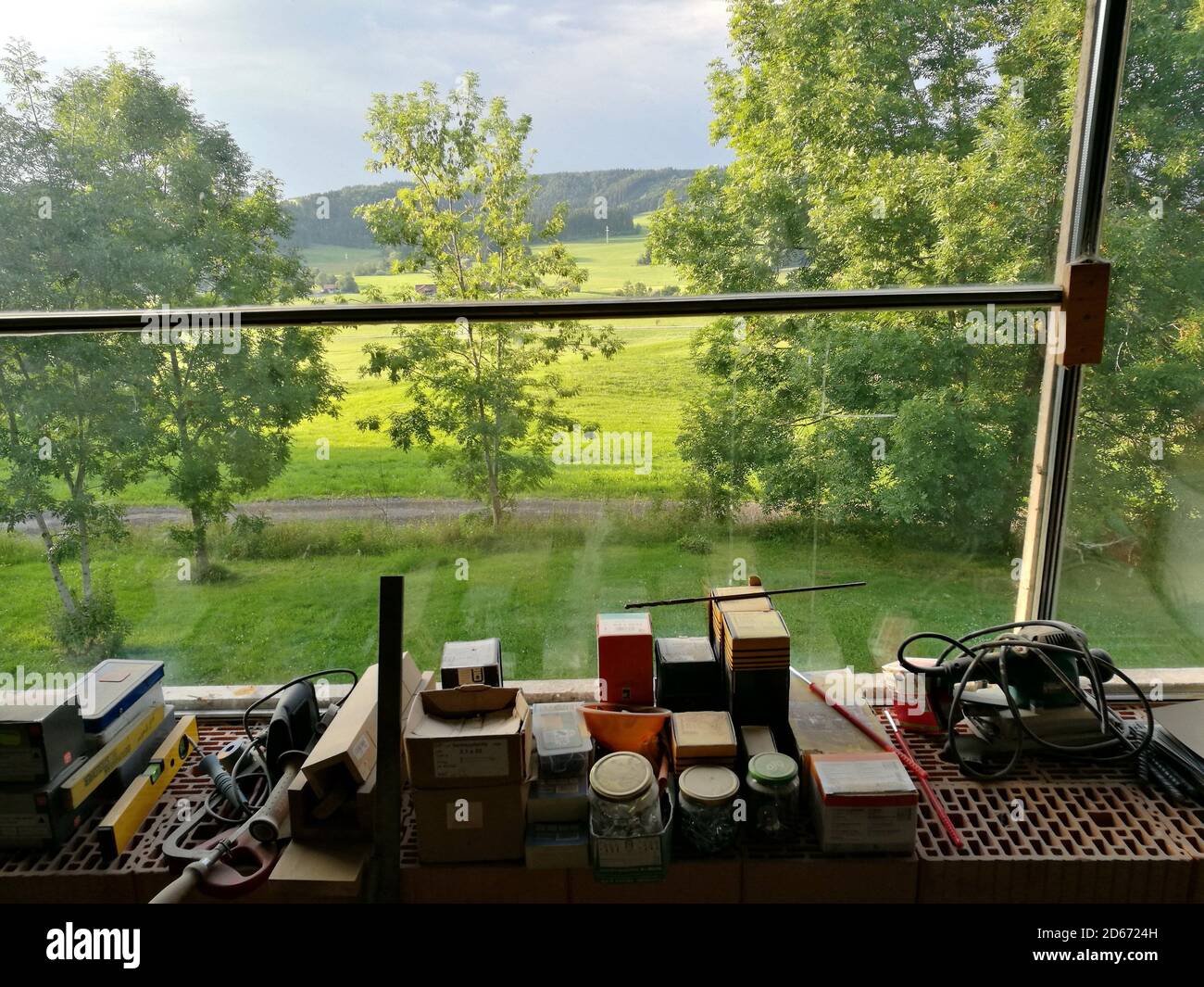 View of different painting materials with a greenery view outside the