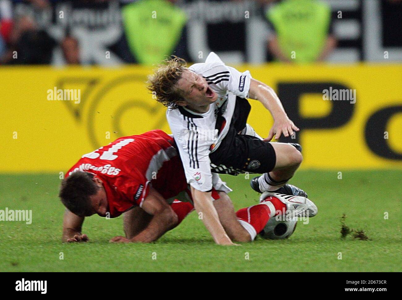 Germany's Marcell Jansen (right) goes to ground after a challenge by Poland's Marek Saganowski. Stock Photo