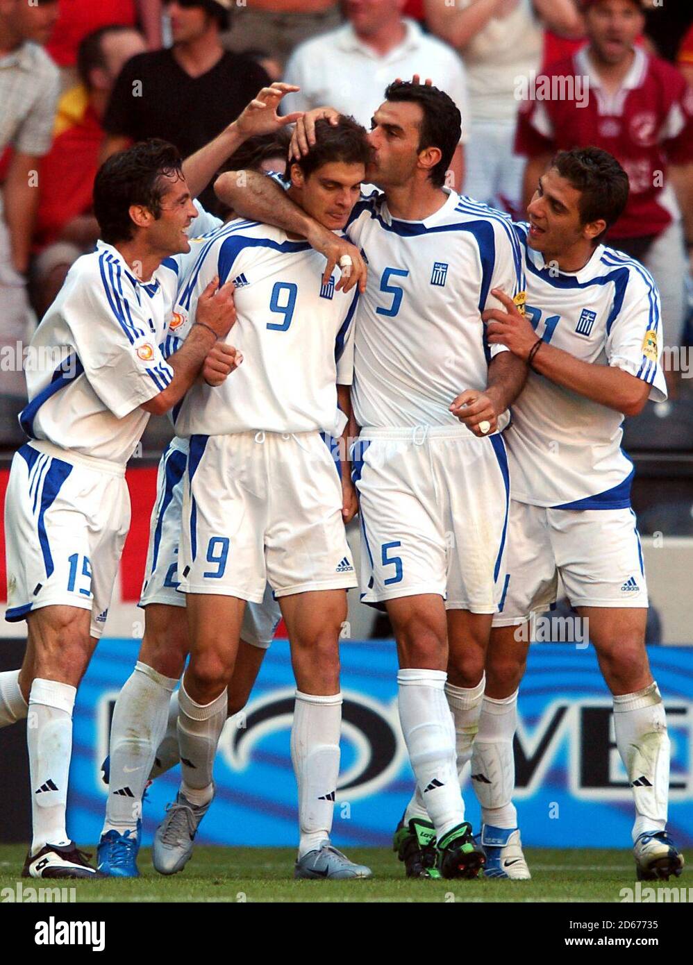 Greece's Angelos Charisteas (no9) celebrates scoring the equalising goal with teammates Zissis Vryzas (L),Traianos Dellas (5), Kostas Katsouranis (21). Stock Photo
