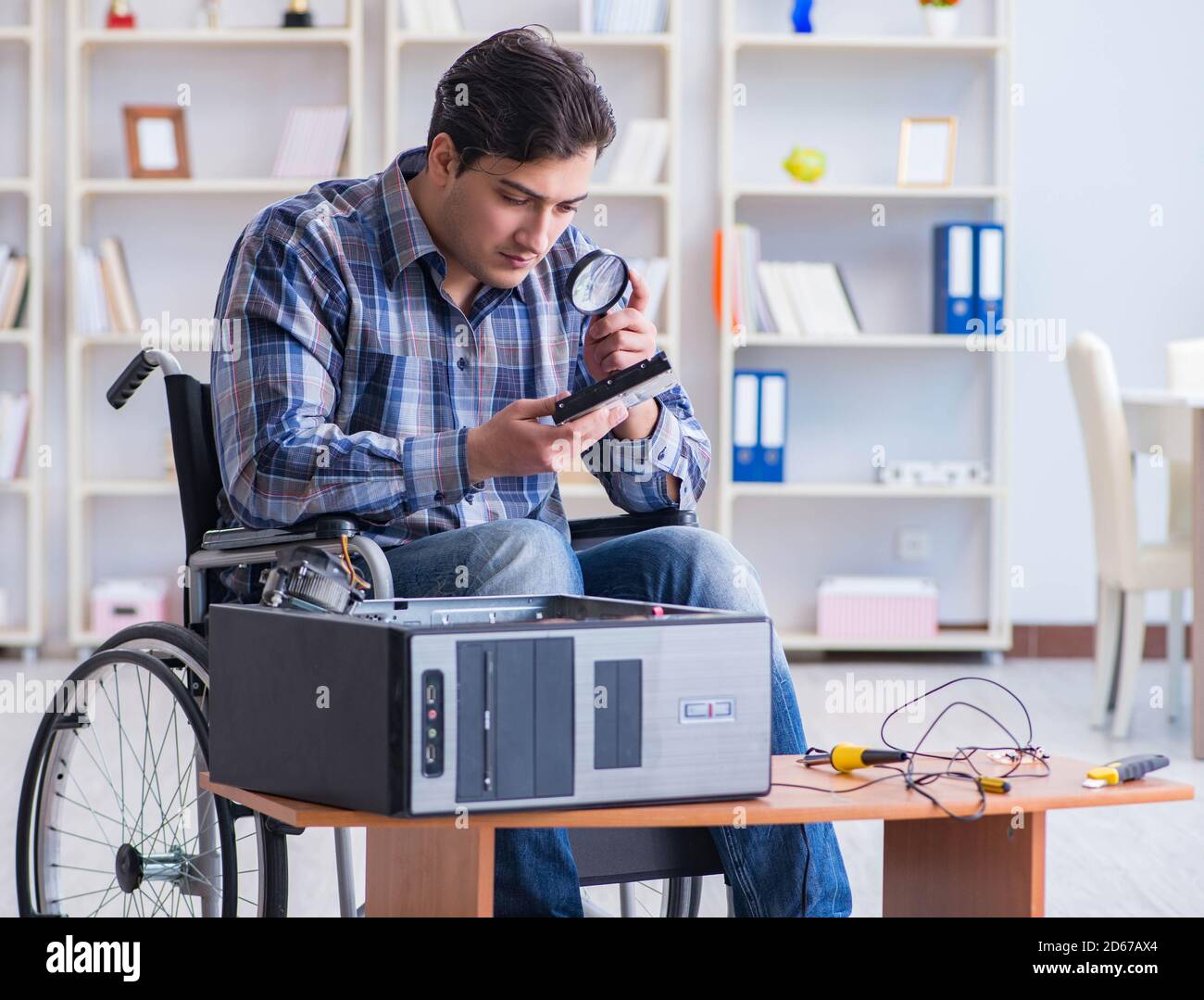 View of The computer repairman on wheelchair working Stock Photo - Alamy