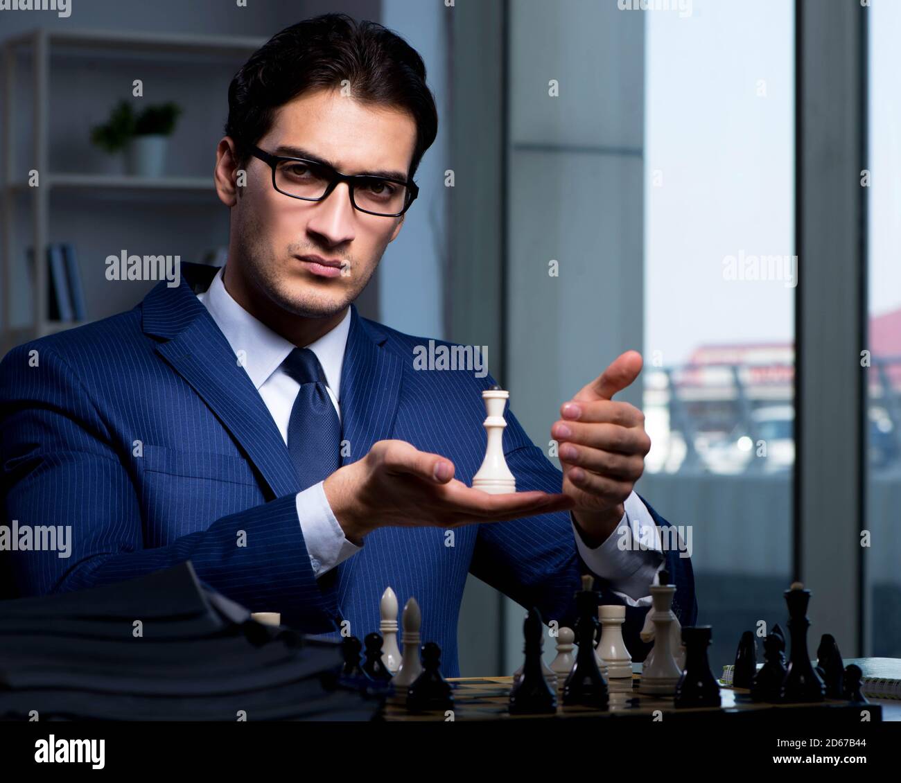 The businessman playing chess in strategy concept Stock Photo - Alamy