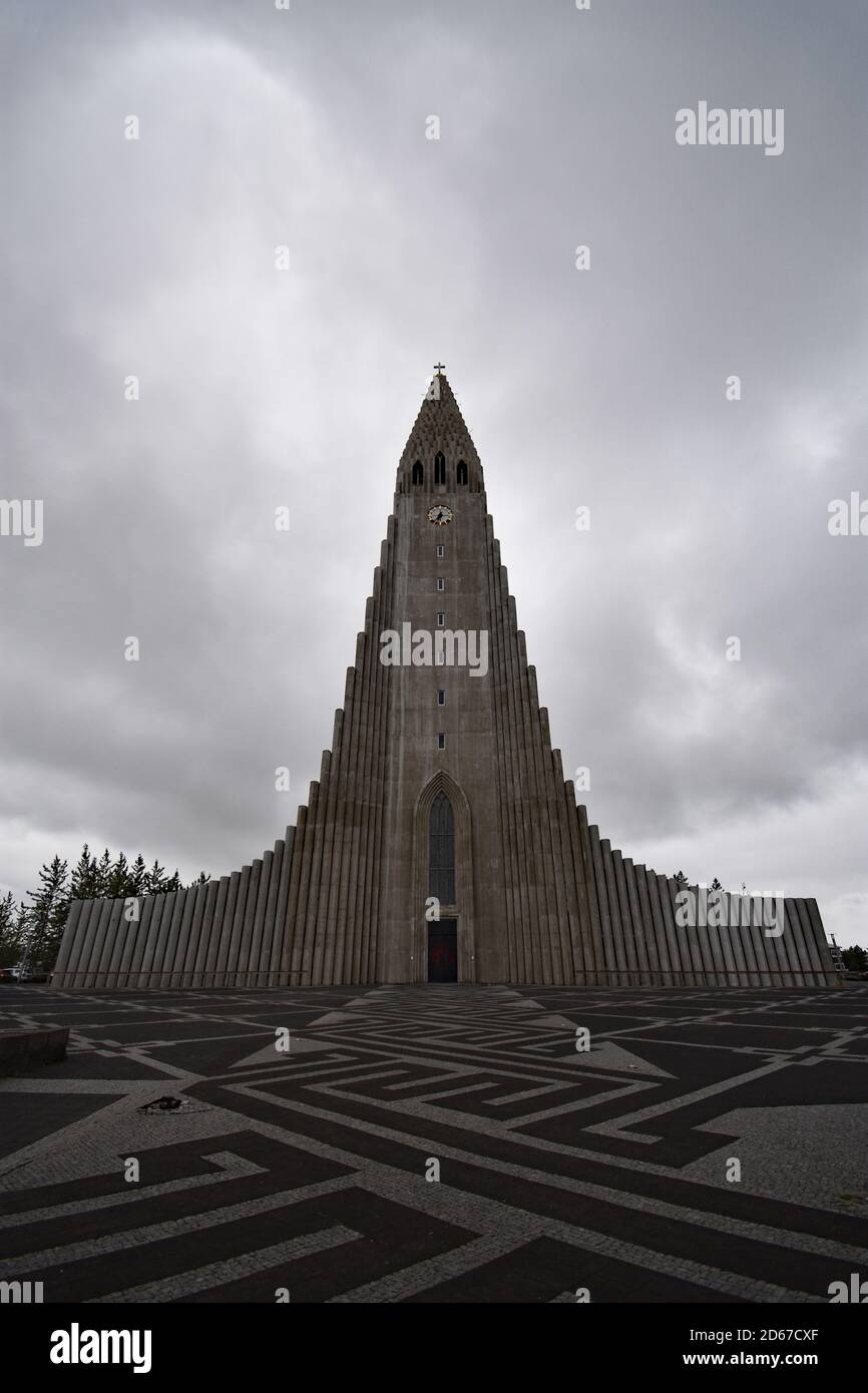 Looking towards Hallgimskirkja Church from the black and white mosaic style plaza in front.  Grey sky with copy space.  Reykjavik, Iceland. Stock Photo