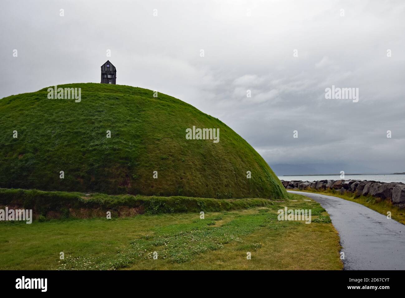 Thufa (Þúfa) by Ólöf Nordal at the entrance to Reykjavik Harbour, Iceland.  A grassy hill with a spiral path leading to a wooden fishing shed on top. Stock Photo
