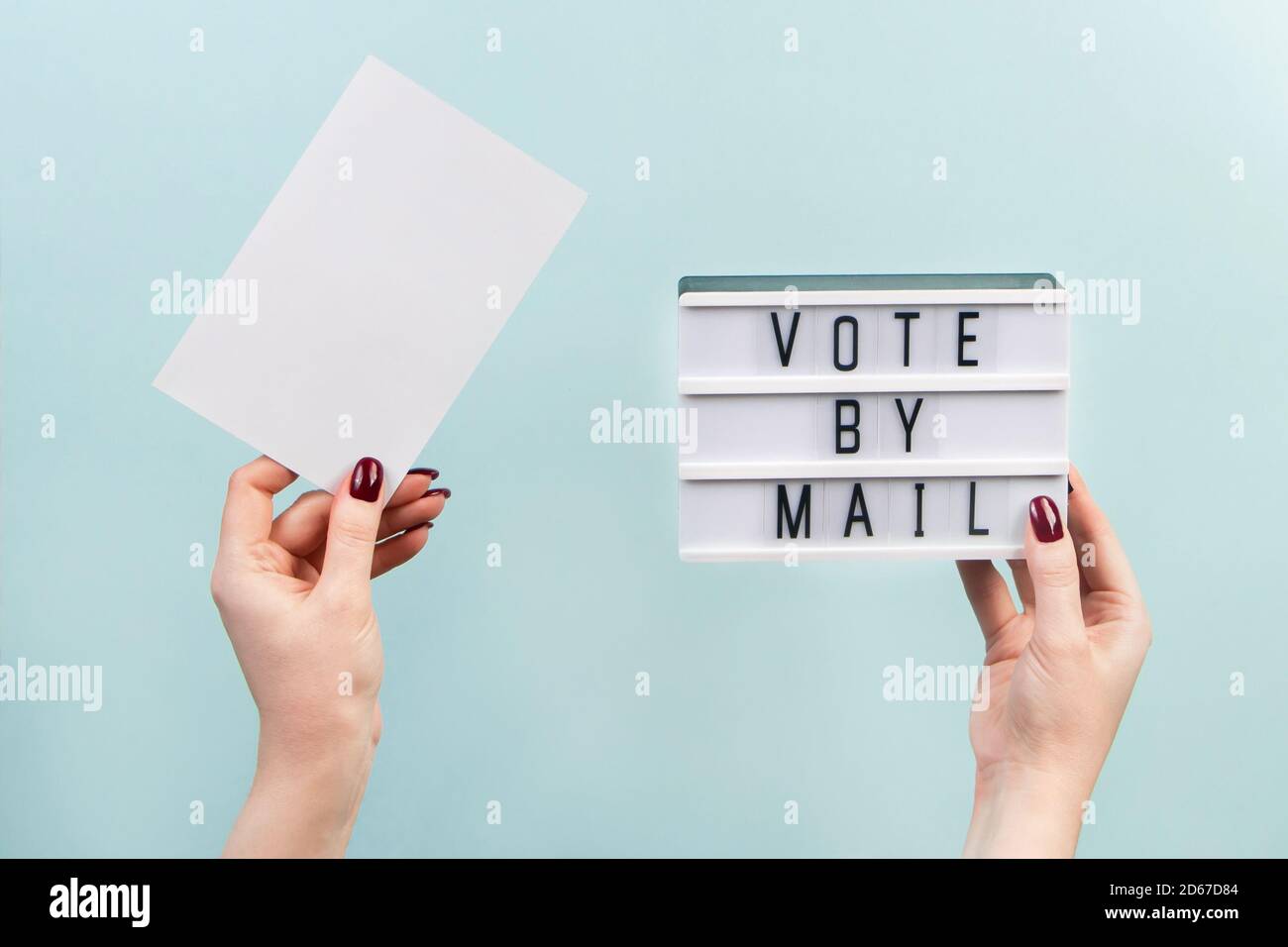 Concept of voting by mail, US elections. A woman holds a sign on a blue background. Stock Photo