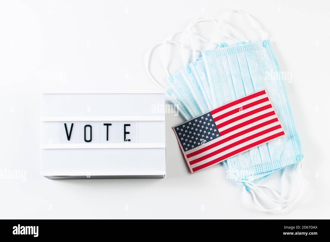 Vote now. Voting concept for the November 3 elections. Medical protective masks and USA flag on white background. Stock Photo