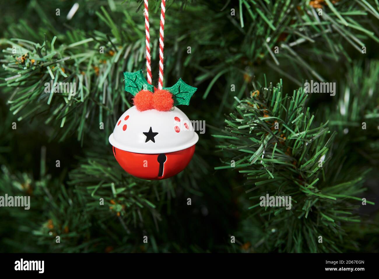 Red and white beautiful decorated bauble hanging from a Christmas tree, copy space Stock Photo