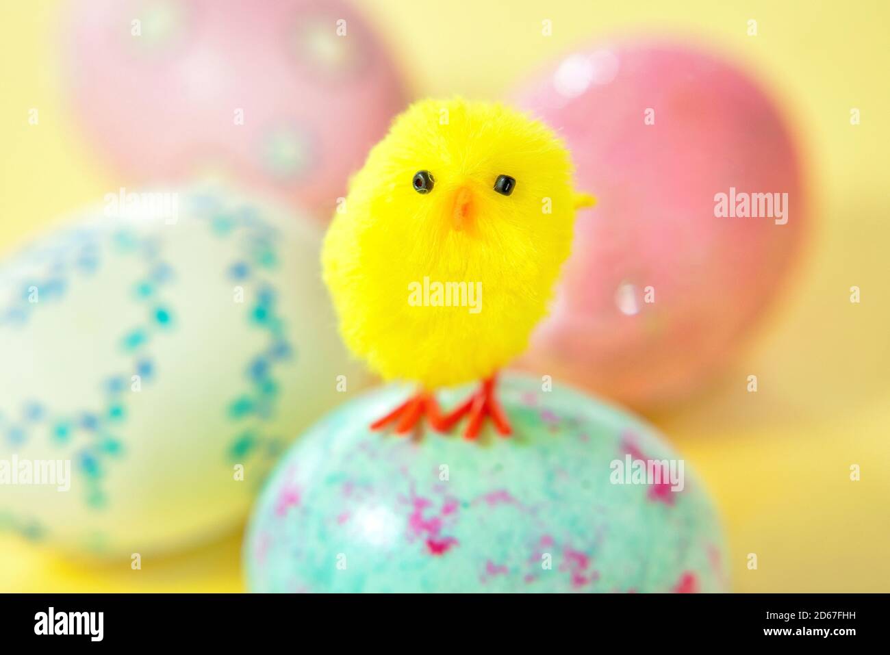 Yellow baby chick standing on Easter egg Stock Photo