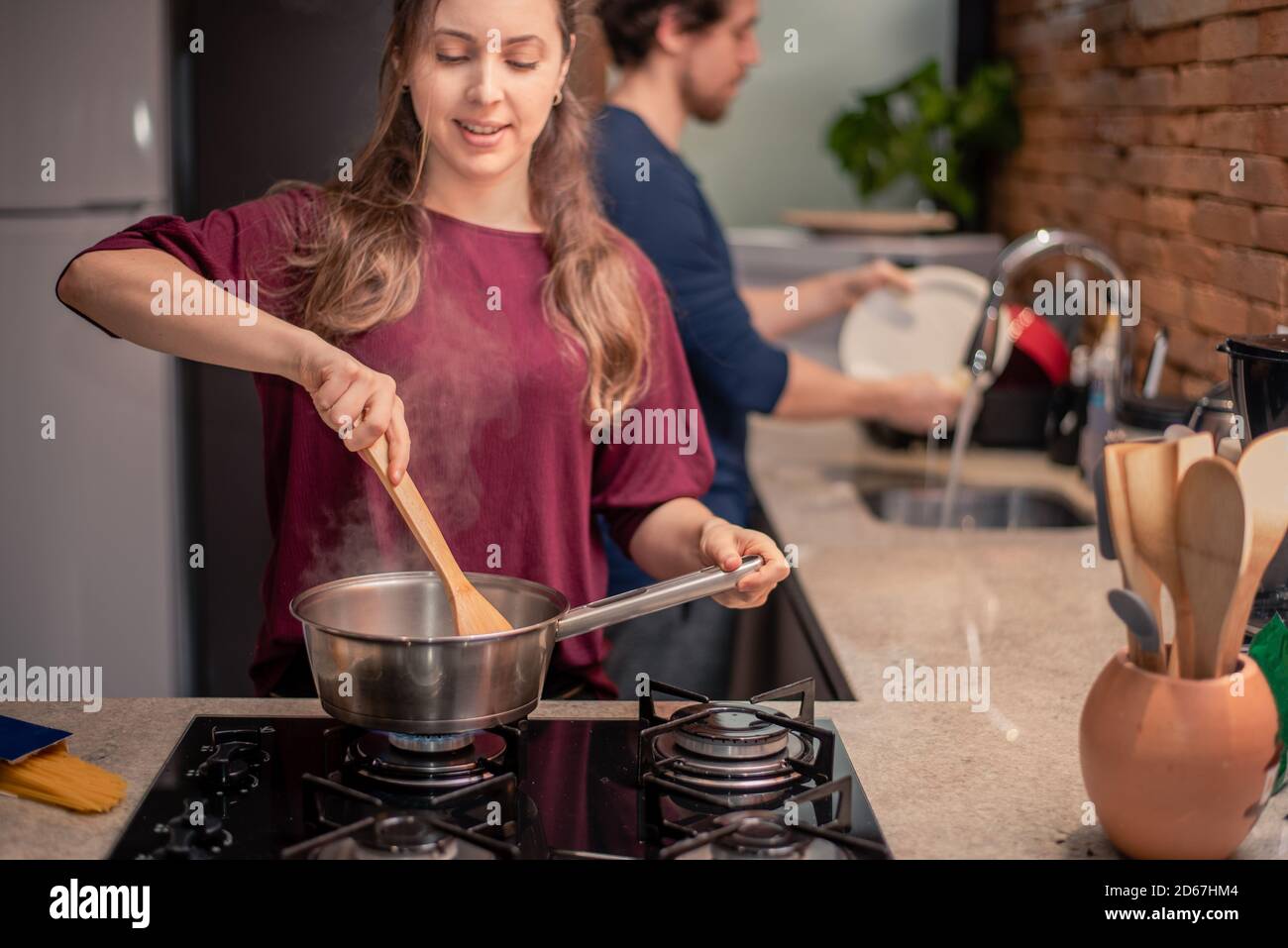 Couple preparing meal and washing dishes Stock Photo