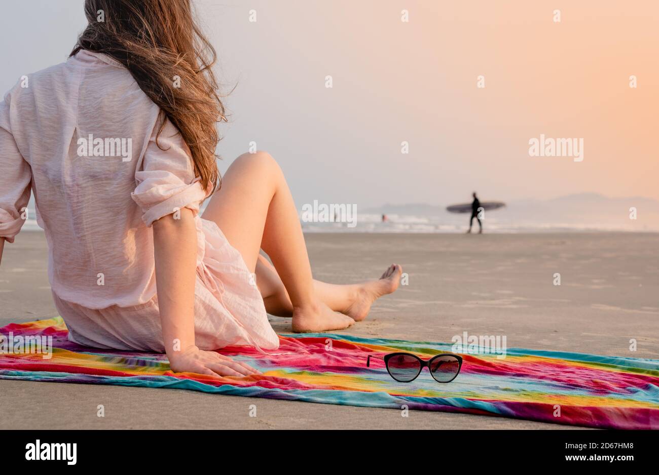 Woman looking at surfer man on the beach Stock Photo - Alamy