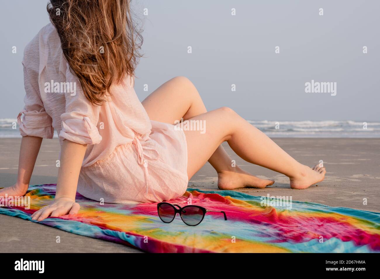 Brazilian woman sitting on sarong on the beach Stock Photo