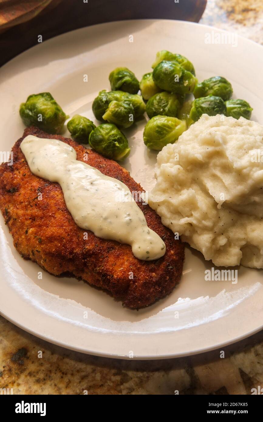 Baked breaded chicken cutlets with brussels sprouts and mashed potatoes