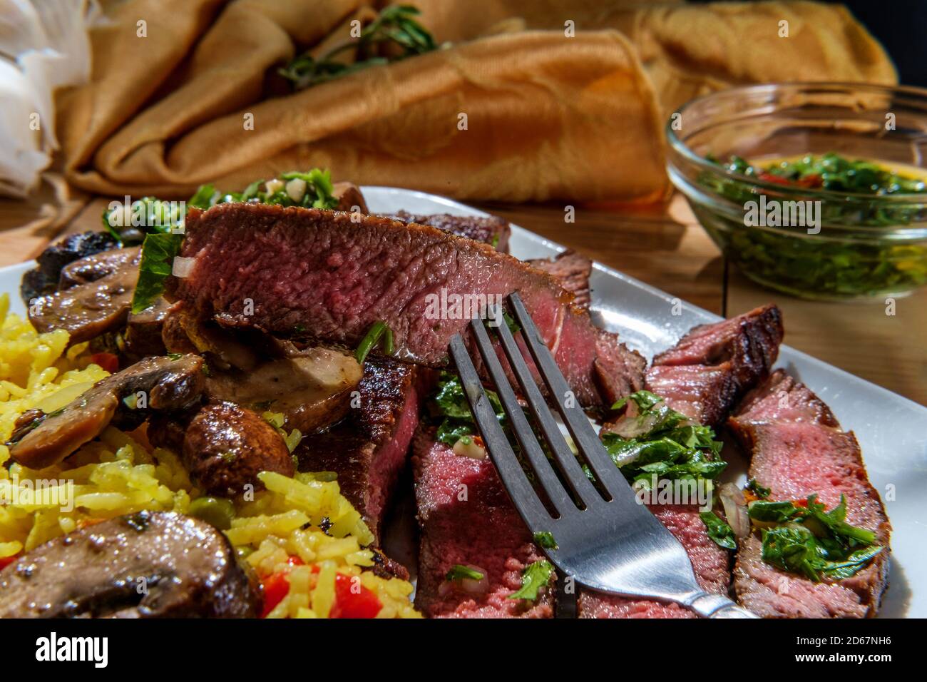 Juicy rare chimichurri verde grilled club steak with yellow rice and