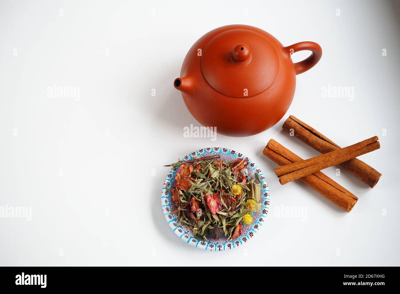 Chinese clay kettle for tea ceremony with herbs and cinnamon sticks. Stock Photo