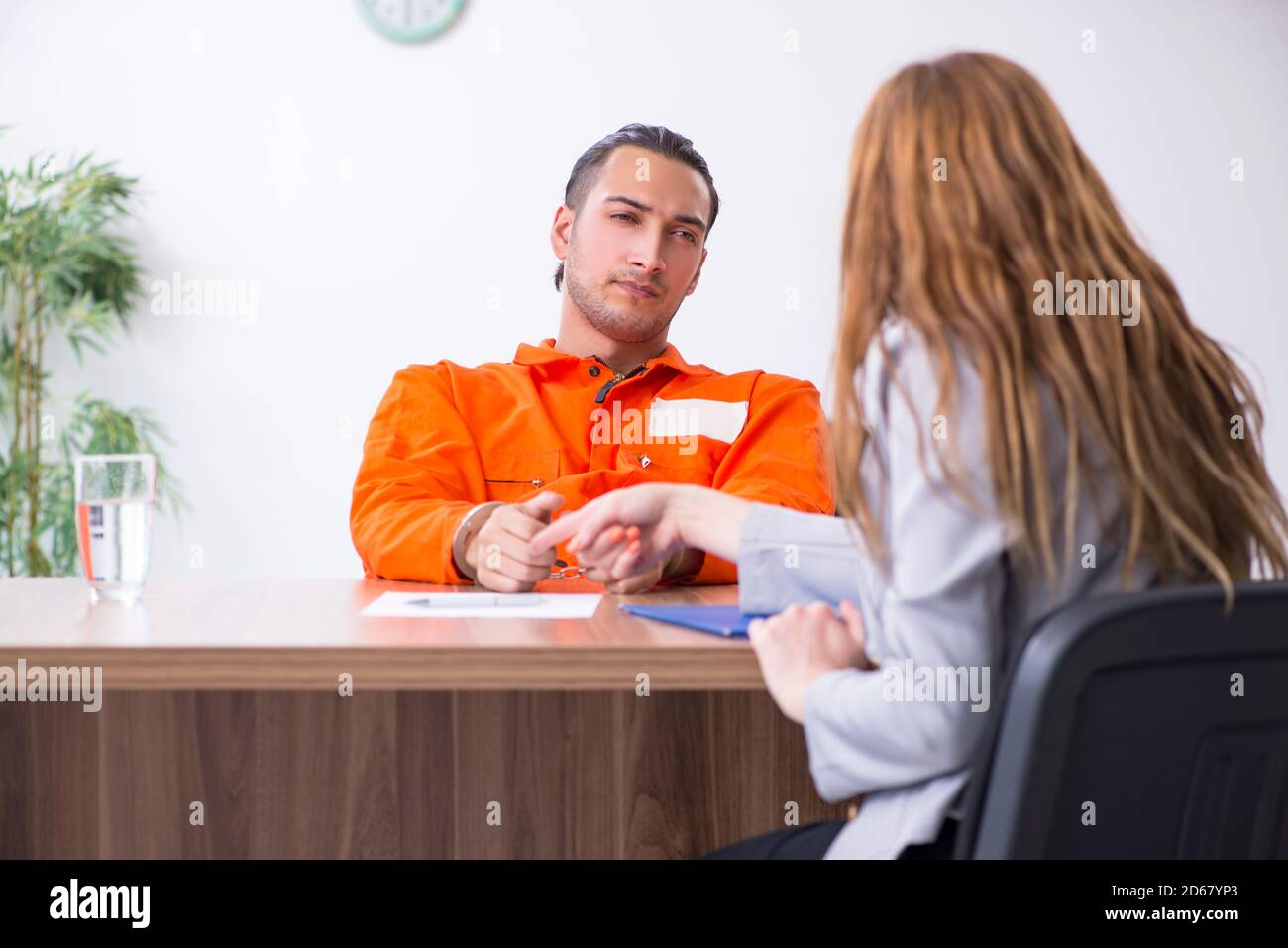 Young man meeting with advocate in pretrial detention Stock Photo