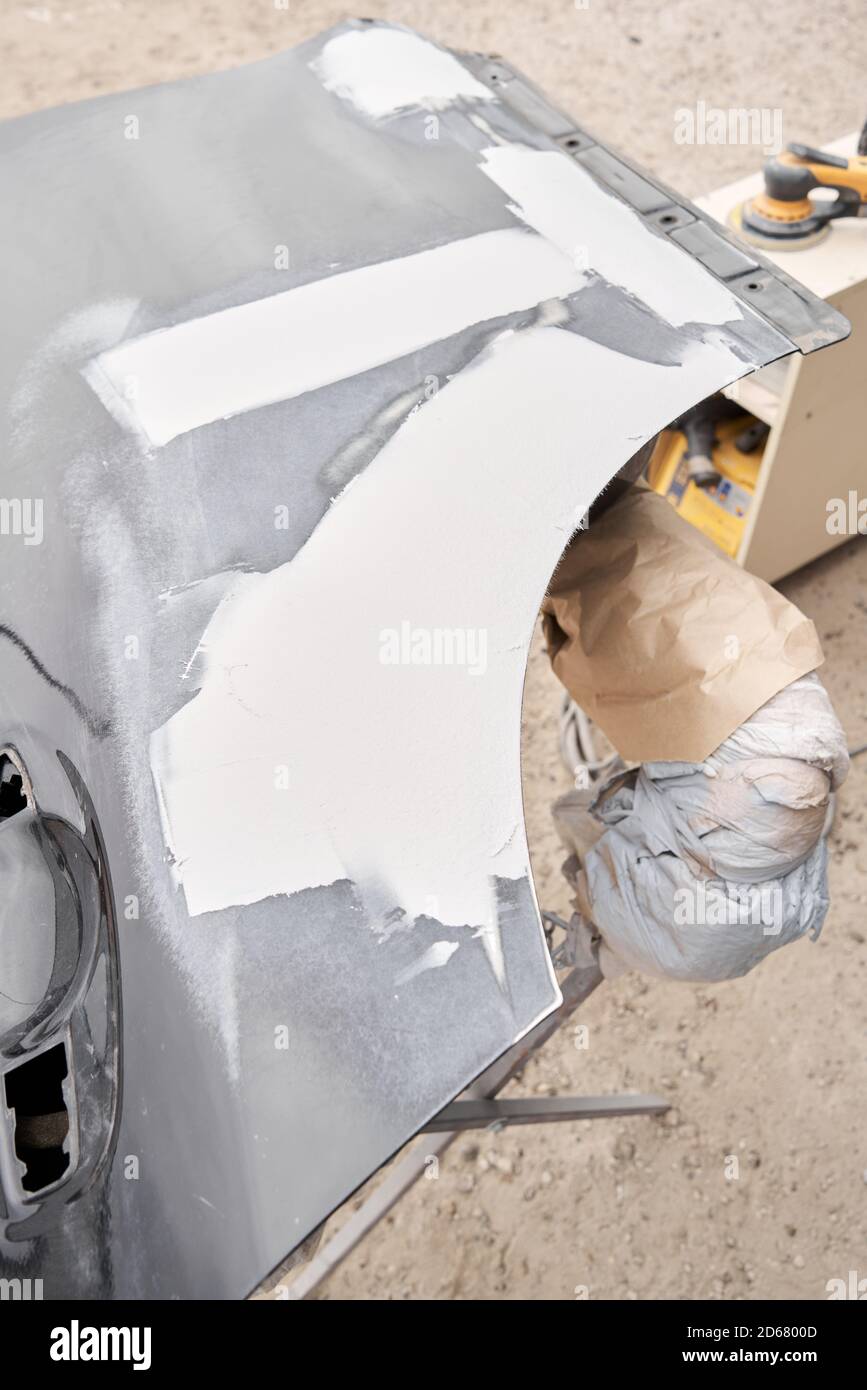 Repairing car body, Application putty close up. The mechanic repair the