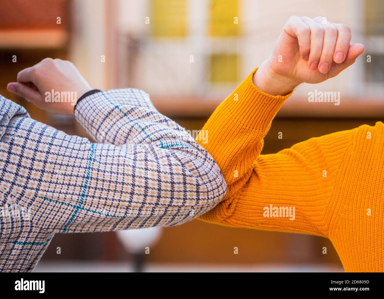 Elbow bump. Bump elbows. Friends shaking elbows outdoors. Elbow