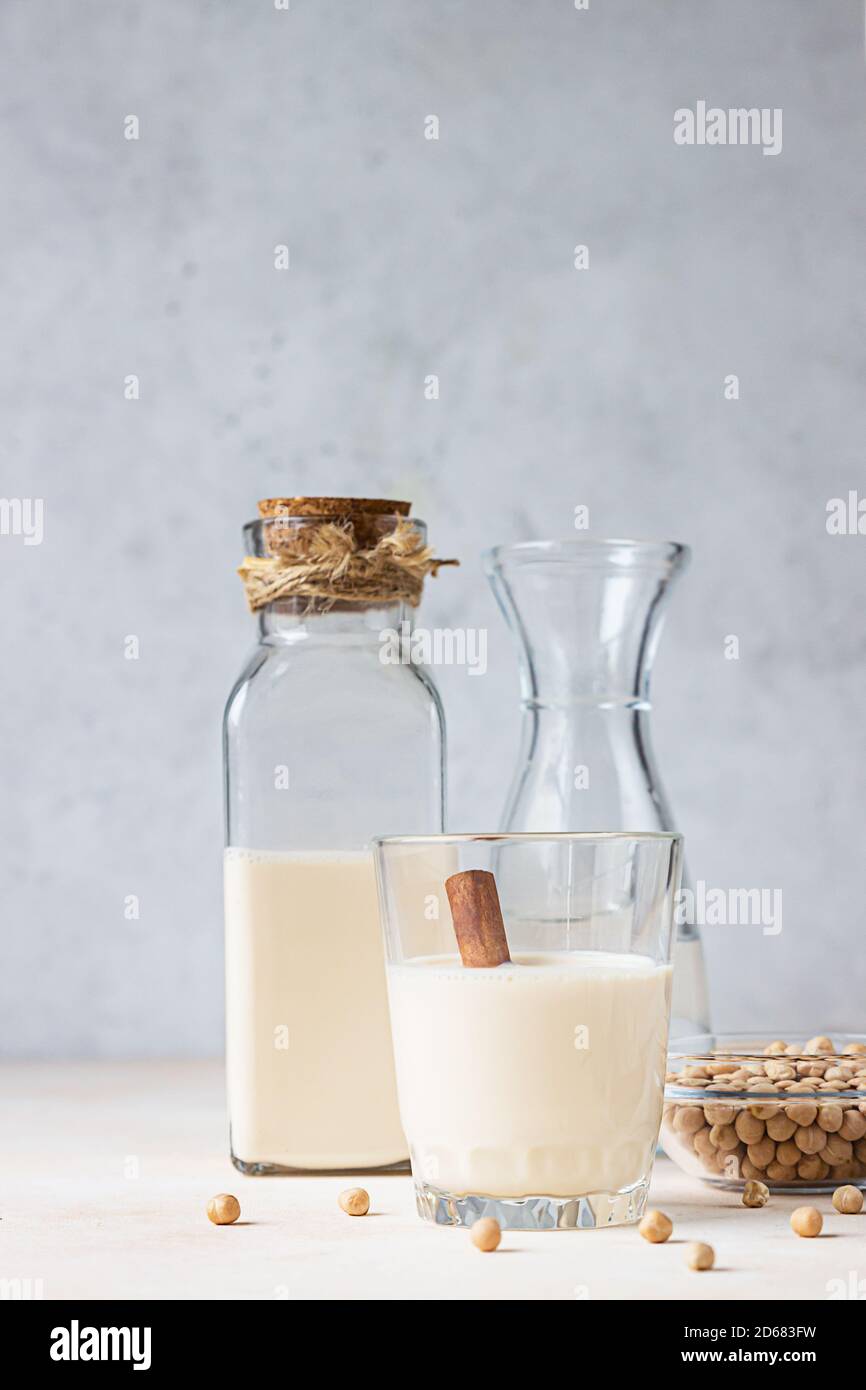 Chickpea vegetarian milk in a bottle and glass and raw chickpeas on light background. Lactose free non dairy products. Healthy vegan food concept. Stock Photo