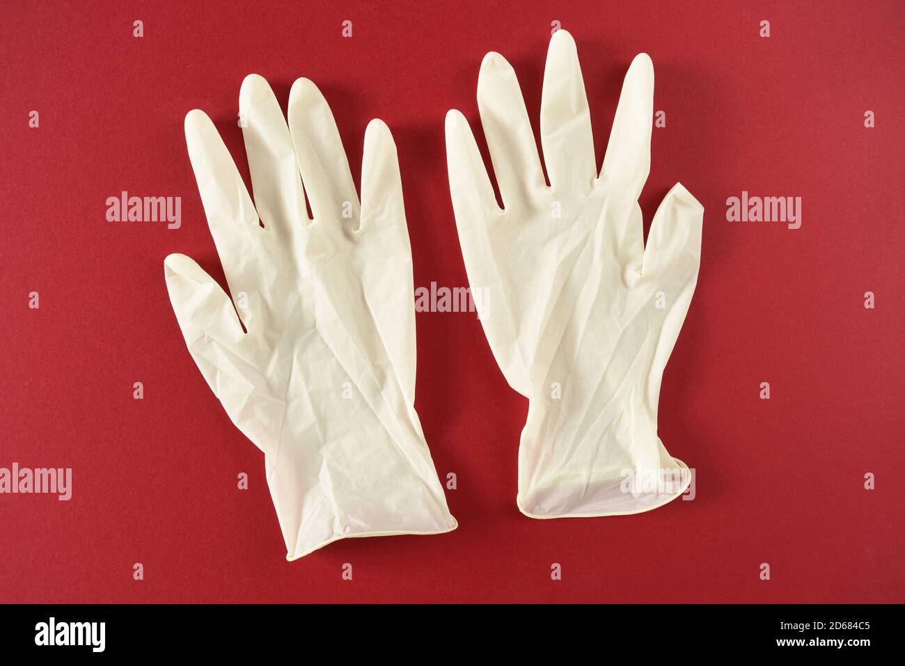 Latex medical gloves on a red backgound Stock Photo