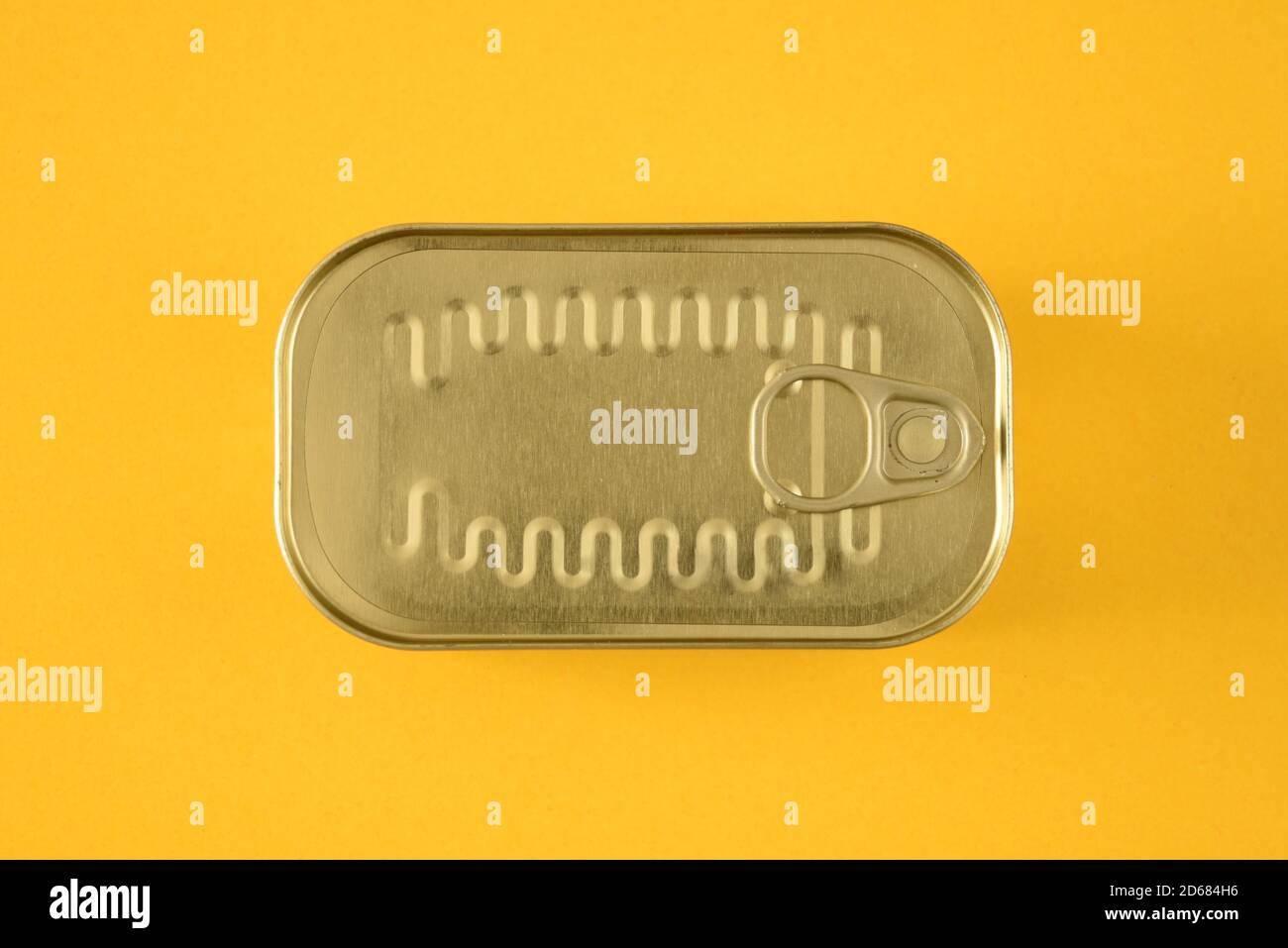 Top of a sardine can with ring pull on a yellow background Stock Photo