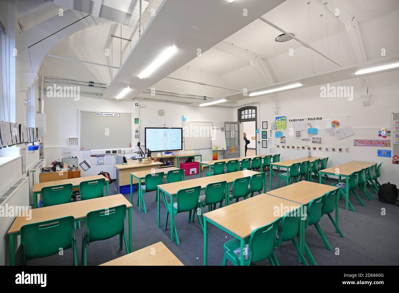Newly refurbished Victorian school classroom with desks arranged facing the front. Traditional layout reintroduced during the Covid pandemic of 2020. Stock Photo