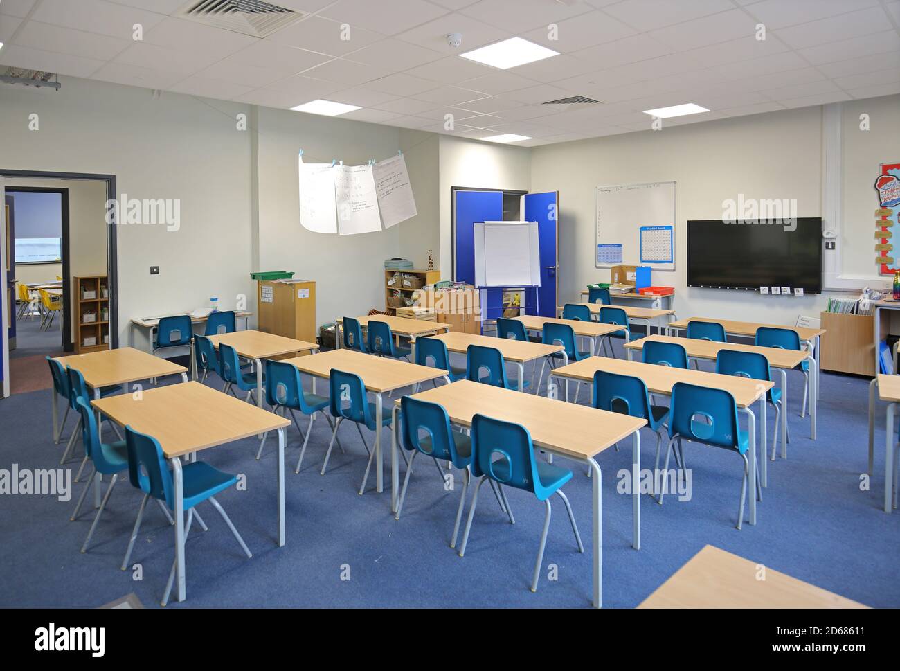 Newly built school classroom with desks arranged in twos, facing the front. A traditional layout reintroduced during the Covid pandemic of 2020. Stock Photo