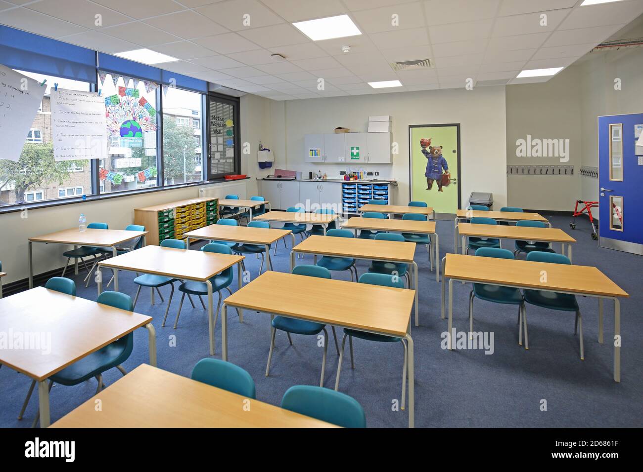 Newly built school classroom with desks arranged in twos, facing the front. A traditional layout reintroduced during the Covid pandemic of 2020. Stock Photo