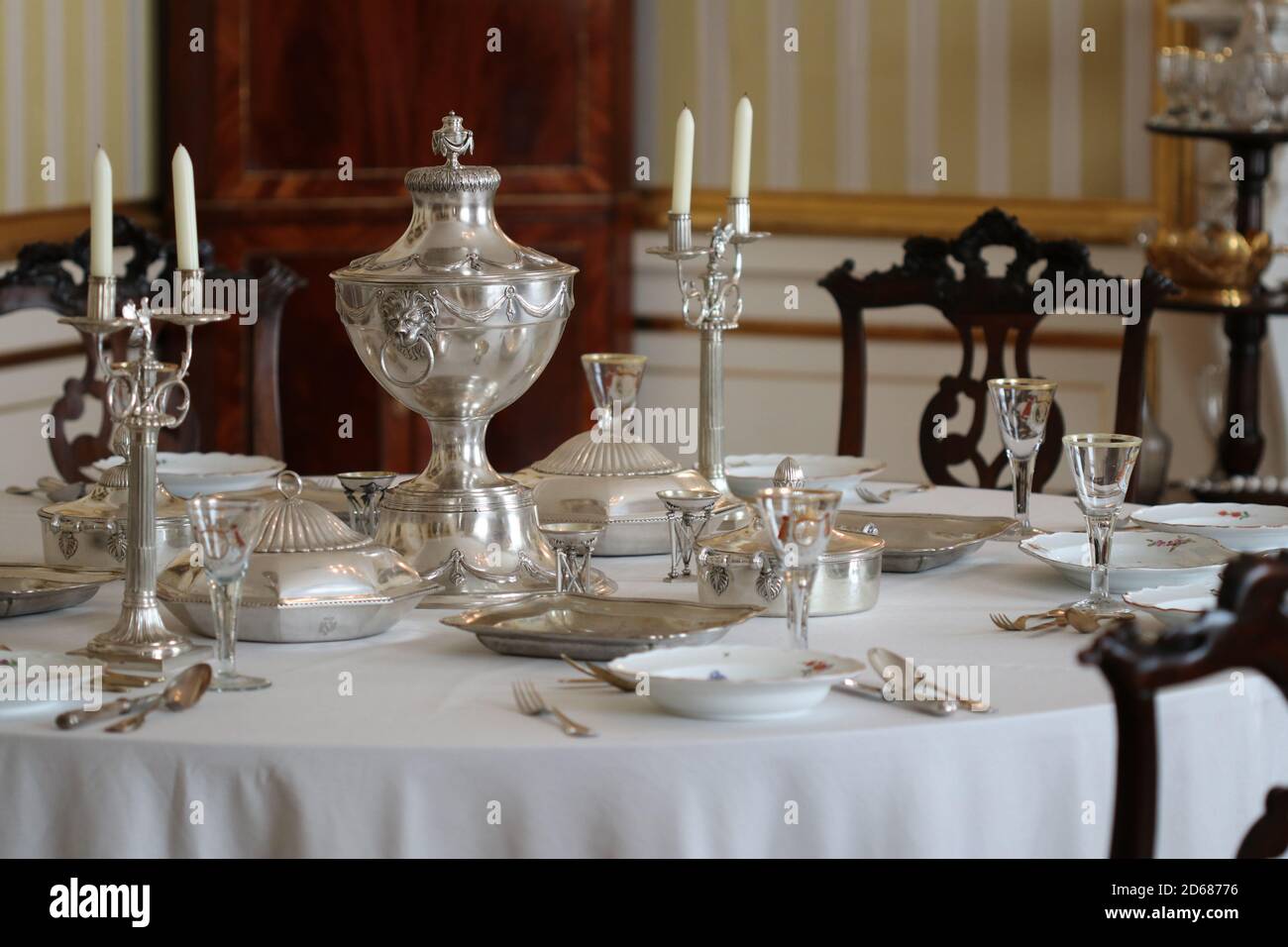 Old vintage silver tableware set out on table with white tablecloth in vintage interior Stock Photo