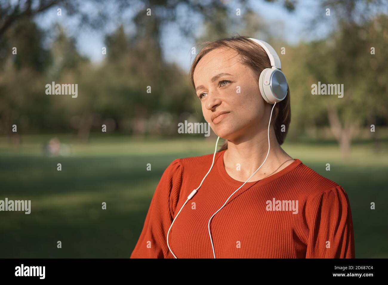 Pregnant woman listening to a music at park Stock Photo - Alamy