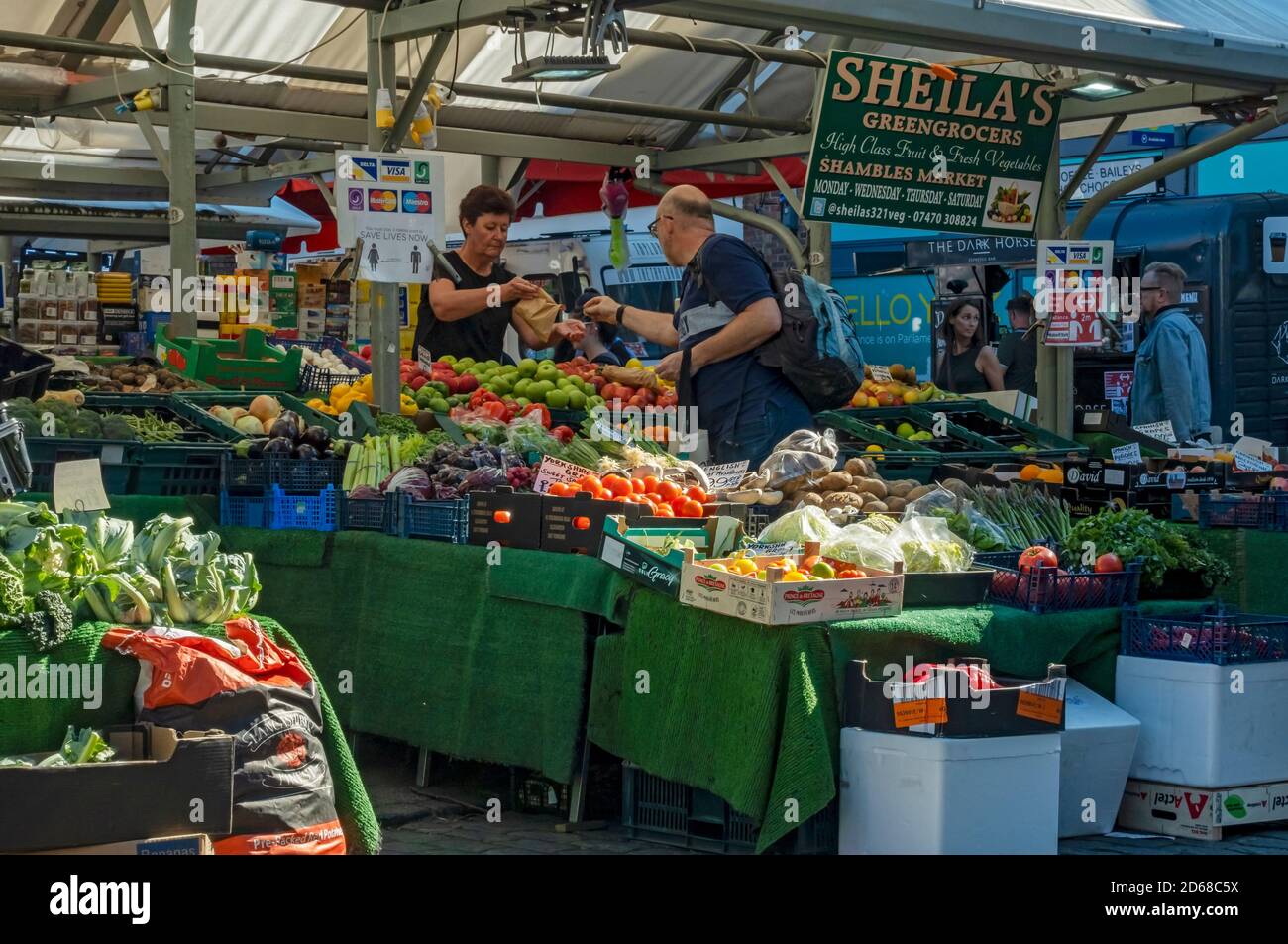 Stall holder selling fresh fruit and vegetables veg at the outdoor market stalls York North Yorkshire England UK United Kingdom GB Britain Stock Photo