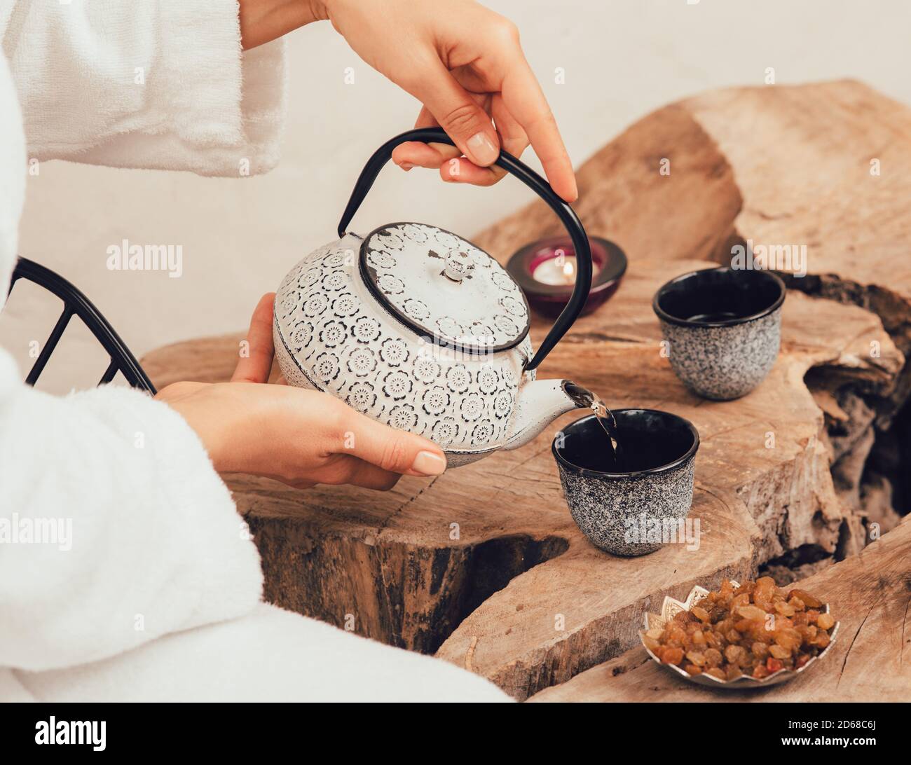 Woman pours wellness tea in spa after massage. Relaxation tea Stock Photo