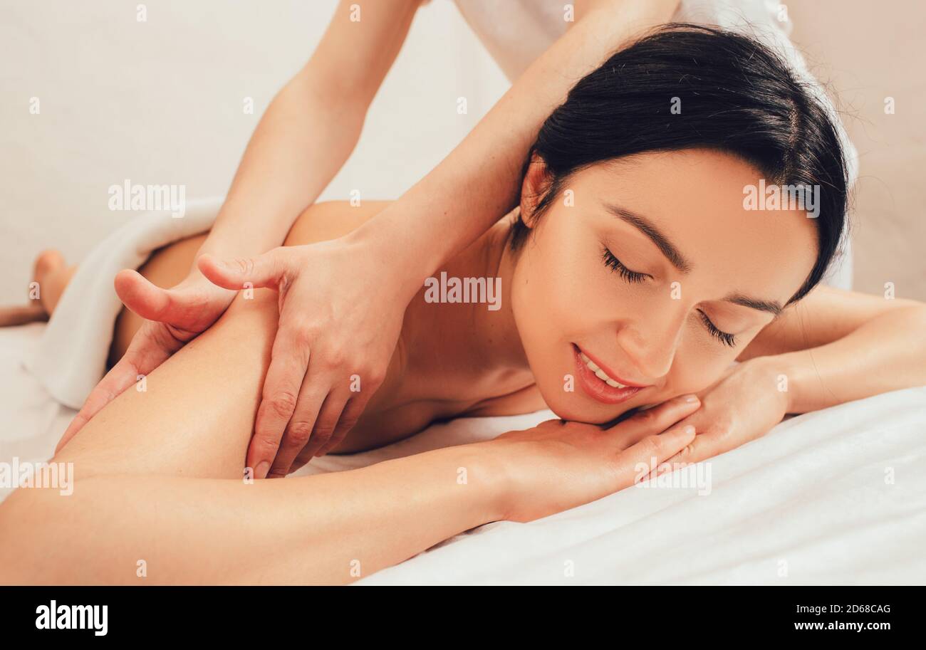 Beautiful mixed race woman enjoying a body massage, Ayurvedic massage using aroma oils. Thai body massage, aroma relaxation Stock Photo