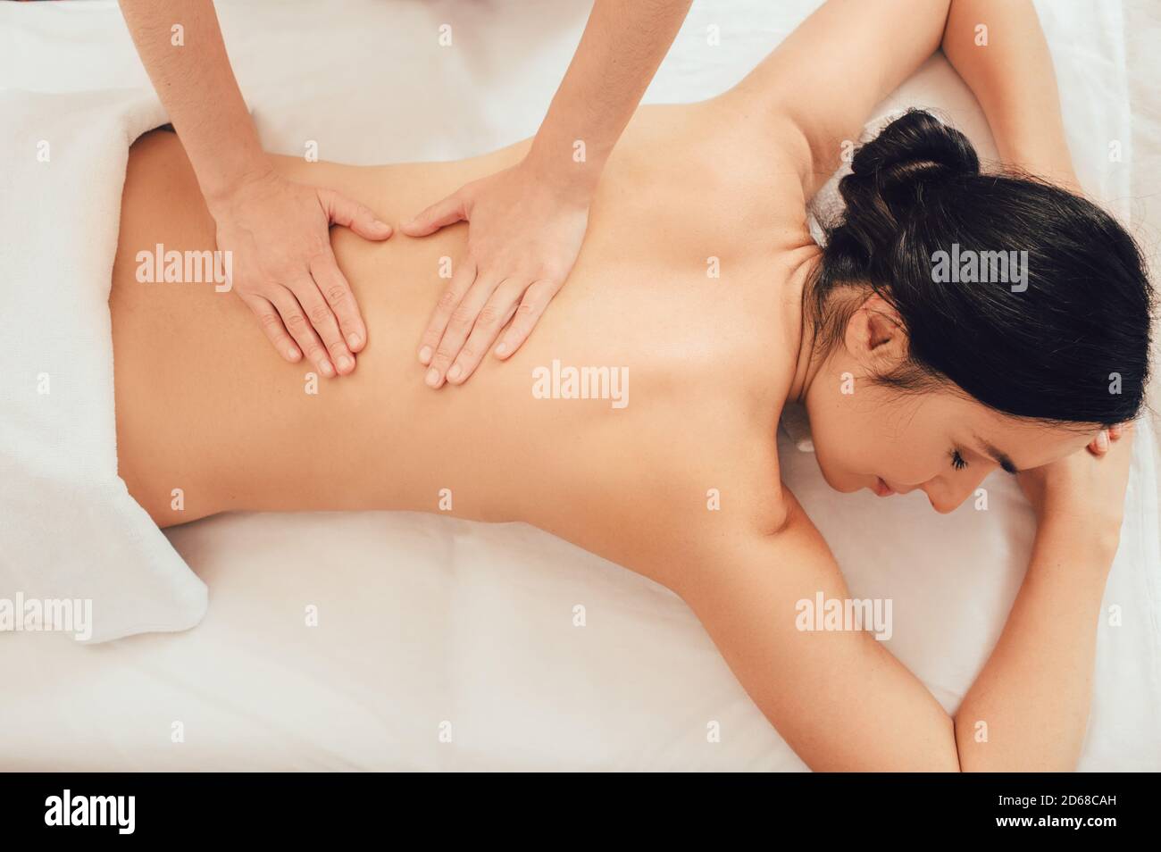 Top view of woman lying on a massage table and receive back massage, spa weekend. Antri-stress massage Stock Photo