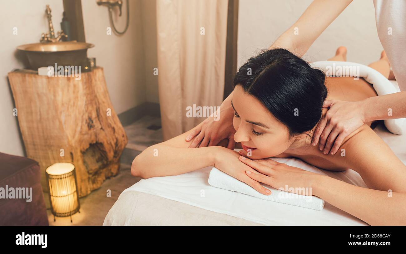 Anti-stress massage. A beautiful brunette woman is getting a back massage at a spa resort Stock Photo